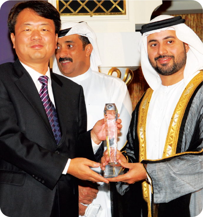Dignitaries exchanging an award at a Middle East Excellence Awards ceremony